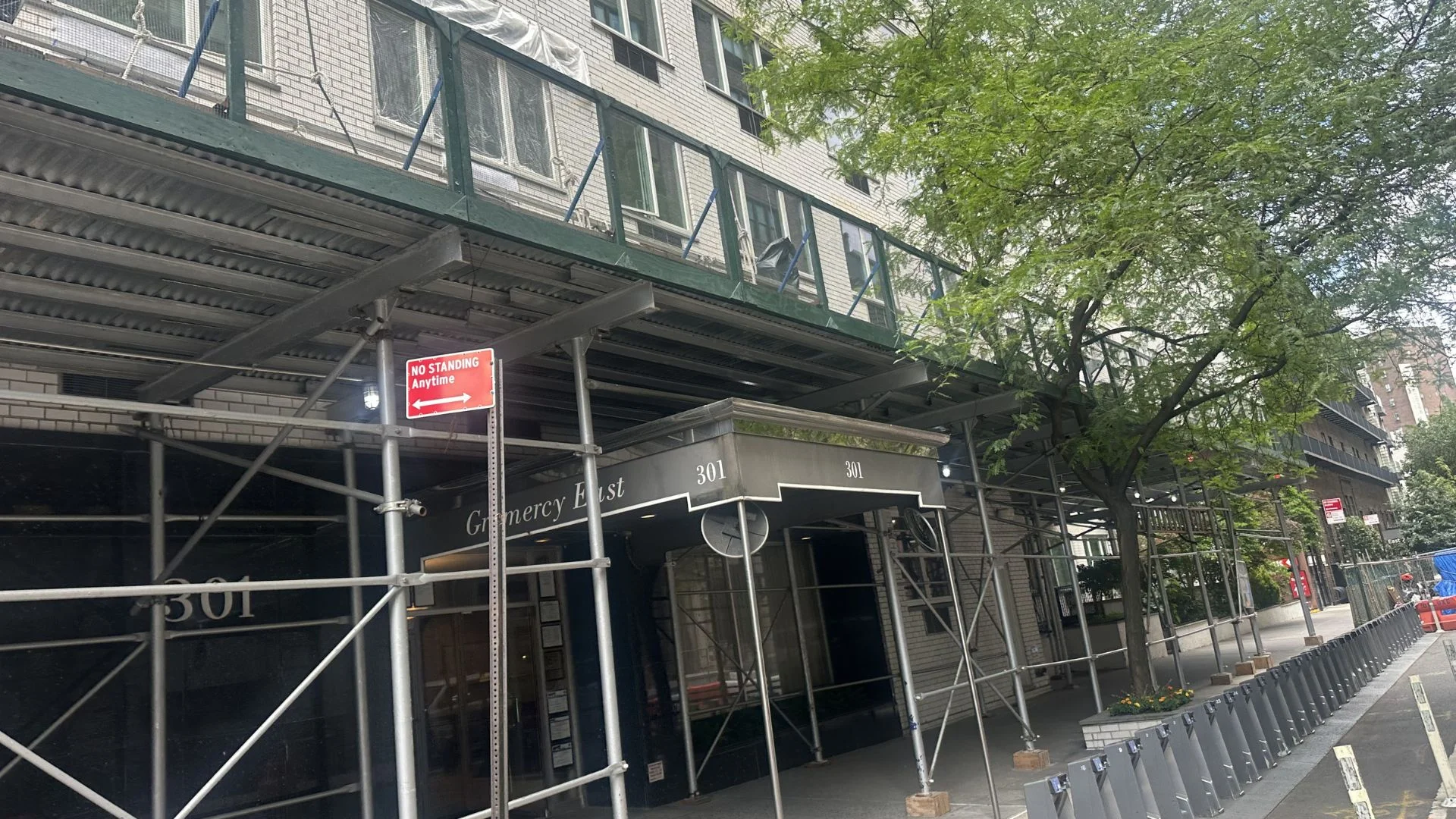 Sidewalk shed and scaffolding covering building entrance in NYC